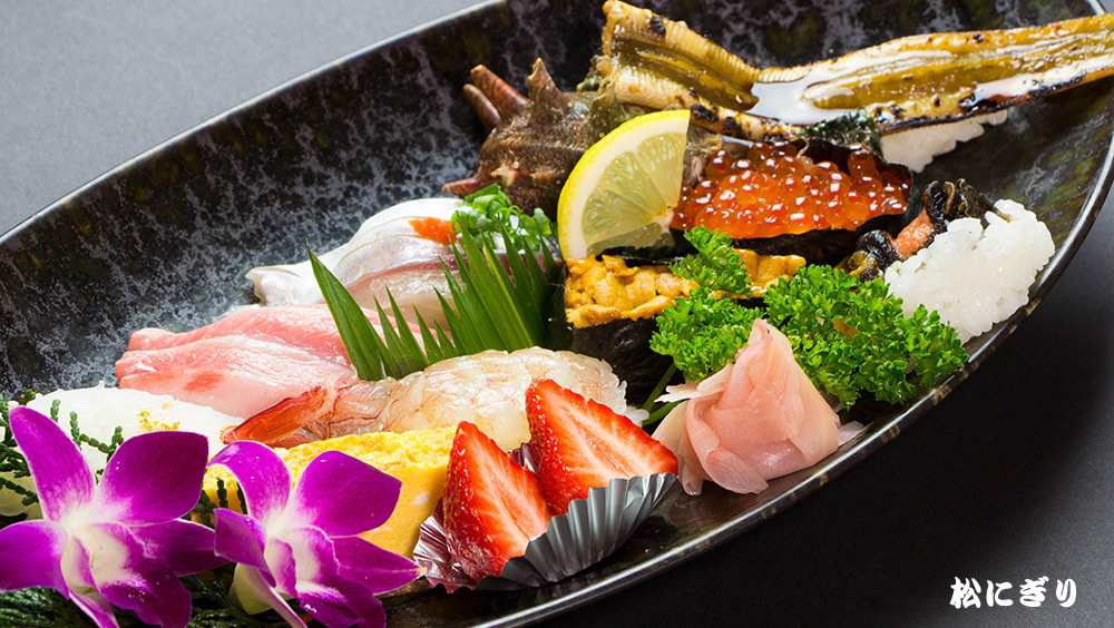 松にぎり。エビ・マグロ・ウニにイクラなど輝くにぎり寿司が華々しく並んでいる写真。